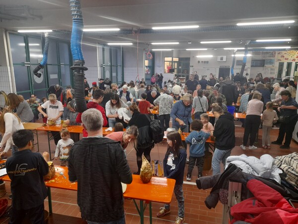 Fahrzeughalle Echterdingen voller Menschen, die Rüben schnitzen und Laternen basteln